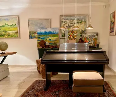 a black piano in a room with paintings at Ellé'Belle Oudsbergen 1-, 2- or 3-Bedrooms in Oudsbergen