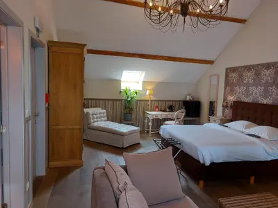 a bedroom with a bed and a couch and a chair at B&B Bloonwinning in Hasselt