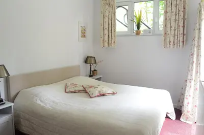 a bedroom with a white bed with a pillow on it at Vakantie Logies de Kleine Motte in Sint-Truiden