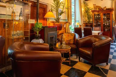 a barber shop with leather chairs and a table at Vakantie Logies de Kleine Motte in Sint-Truiden