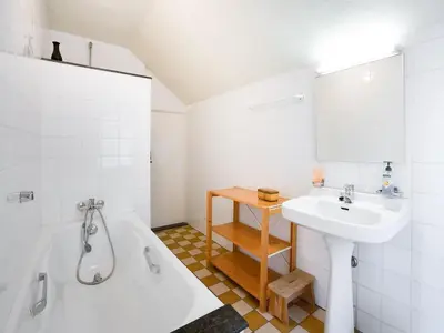 a white bathroom with a sink and a bath tub at Voeren Mansion with Garden in Voeren