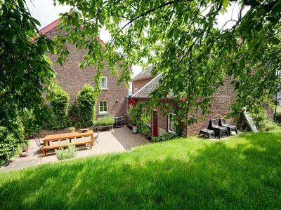 a garden with a bench and chairs in front of a building at Voeren Mansion with Garden in Voeren