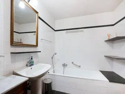a white bathroom with a sink and a bath tub at Voeren Mansion with Garden in Voeren