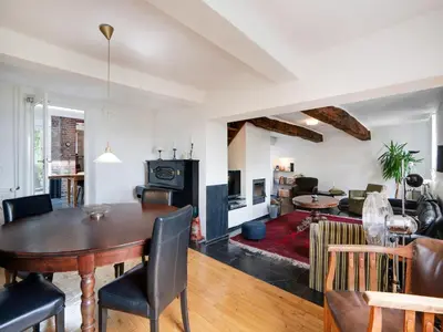 a living room with a table and a living room with a fireplace at Voeren Mansion with Garden in Voeren