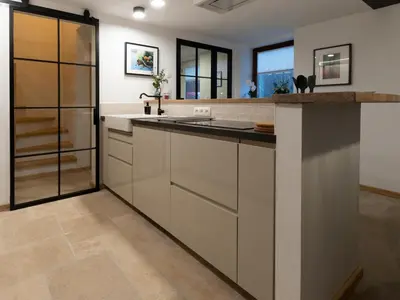 a kitchen with white cabinets and a sink at Bellerose Maison de Greunebennet in Plombières