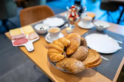 a table with a plate of bread and pastries on it at B&B Punto Vélo in Zutendaal
