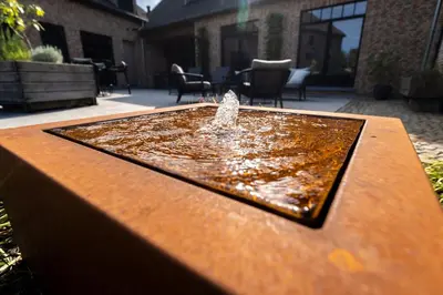 a water fountain sitting on top of a wooden table at B&B Punto Vélo in Zutendaal