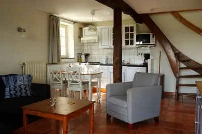 a living room with a kitchen and a dining room at Hoeve Espewey Cottage in Hombourg