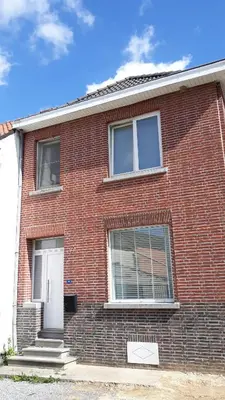 a brick house with two windows and a white door at Kanne: charming house between nature and shopping in Kanne