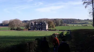 a group of people walking up a hill to a house at Kanne: charming house between nature and shopping in Kanne
