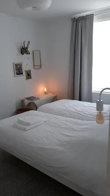 a bedroom with a white bed and a window at Kanne: charming house between nature and shopping in Kanne