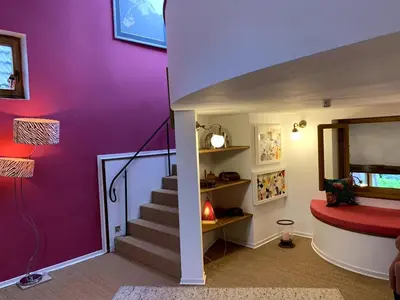 a room with purple walls and a staircase with a red seat at Gite de Caractère Le Lys Bleu in Limbourg