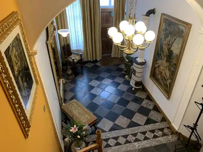 a hallway with a staircase with paintings on the walls at Gite de Caractère Le Lys Bleu in Limbourg