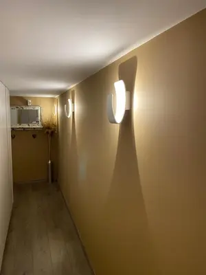 a hallway with two lights on the wall at Le Retour aux Sources - Chambre d'Hôte chaleureuse et conviviale in Chaudfontaine