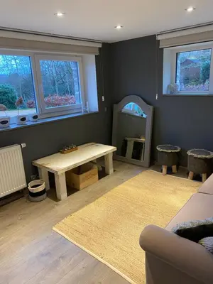 a living room with a table and a mirror at Le Retour aux Sources - Chambre d'Hôte chaleureuse et conviviale in Chaudfontaine