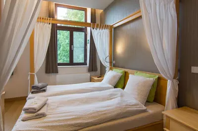 two beds in a bedroom with a window at Het Dorpshuys - vakantiewoning tot 12 personen in Maaseik