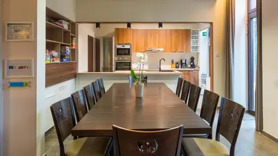 a kitchen and dining room with a wooden table and chairs at Het Dorpshuys - vakantiewoning tot 12 personen in Maaseik