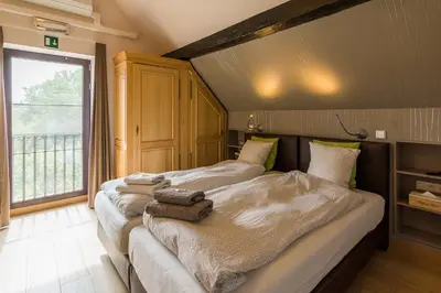 two beds in a room with towels on them at Het Dorpshuys - vakantiewoning tot 12 personen in Maaseik