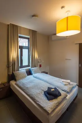 a bedroom with a large bed with a yellow ceiling at Het Dorpshuys - vakantiewoning tot 12 personen in Maaseik