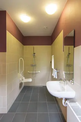 a bathroom with a sink and a mirror at Het Dorpshuys - vakantiewoning tot 12 personen in Maaseik