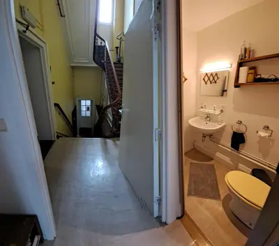 a hallway with a bathroom with a sink and a toilet at Le Piercot in Liège