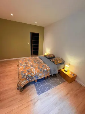a bedroom with two beds and a wooden floor at Le Piercot in Liège