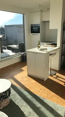 a kitchen with white cabinets and a large window at Gezellig 1 slaapkamer appartement nabij het stadscentrum in Hasselt