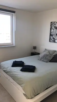 a bedroom with a large bed with two pillows on it at Gezellig 1 slaapkamer appartement nabij het stadscentrum in Hasselt