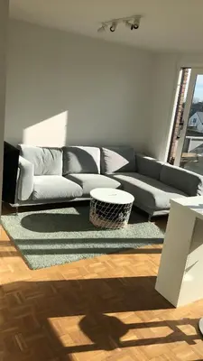 a living room with a couch and a rug at Gezellig 1 slaapkamer appartement nabij het stadscentrum in Hasselt
