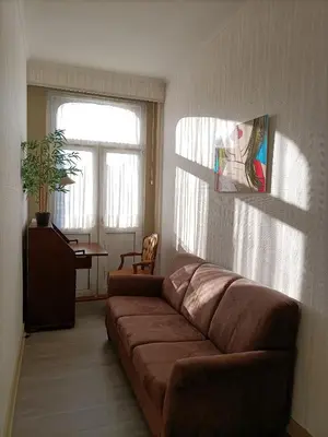 a living room with a brown couch and a window at Moodraz vakantiehuis centrum Peer in Peer
