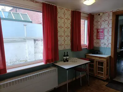 a room with red curtains and a table with bottles of wine at Moodraz vakantiehuis centrum Peer in Peer