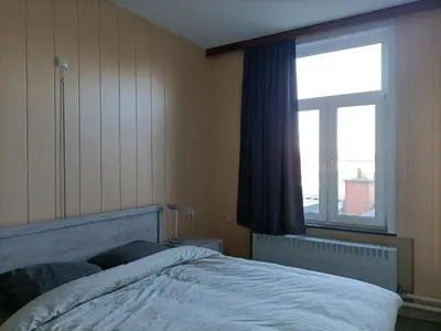 a bedroom with a bed and a large window at Moodraz vakantiehuis centrum Peer in Peer
