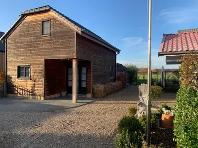 a small brick building with a large doorway at Maas Lodge in Maaseik