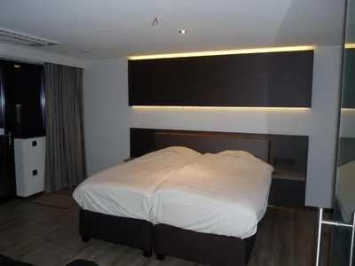 a bedroom with a white bed in a room at Hotel Au Prince Royal in Leopoldsburg