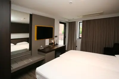 a hotel room with a bed and a television at Hotel Au Prince Royal in Leopoldsburg