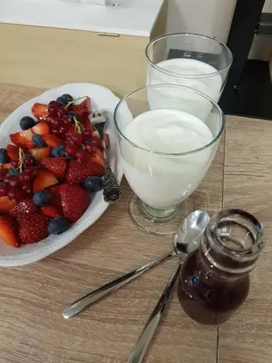 a plate of strawberries and blueberries and a bowl of milk at B&B Le Jardin in Pelt