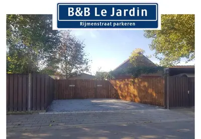 a wooden fence with a gate in a yard at B&B Le Jardin in Pelt