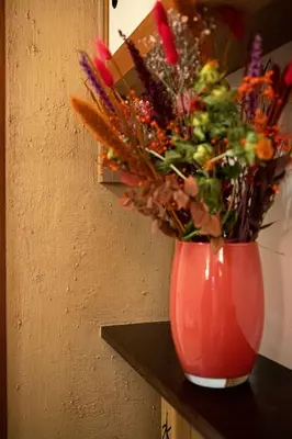 a red vase with flowers in it sitting on a table at Wabi Sabi B&B in Peer