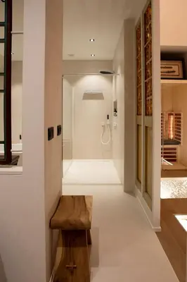a bathroom with a walk in shower and a wooden bench at Wabi Sabi B&B in Peer