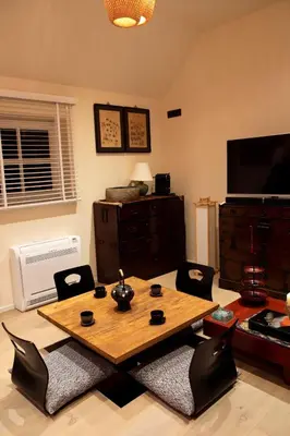 a living room with a wooden table and chairs at Wabi Sabi B&B in Peer