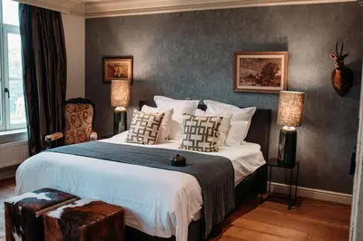 a bedroom with a large bed with two lamps on it at B&B Maison Mairie Hasselt in Hasselt