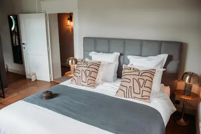 a bedroom with a large white bed with pillows at B&B Maison Mairie Hasselt in Hasselt