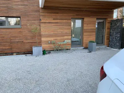 a house with a table and chairs in front of it at Green studio-Situé à 15 min de Botrange, Parc Hautes Fa gnes et Francorchamps in Heusy