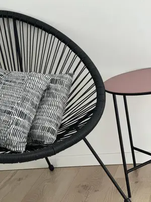 a black chair with two pillows and a table at Domum in Dilsen-Stokkem