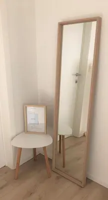 a mirror sitting next to a table and a stool at Domum in Dilsen-Stokkem