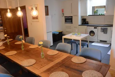 a kitchen and dining room with a wooden table and chairs at Vakantiewoning Het Wielje Maasland in Kinrooi