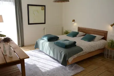 a bedroom with a bed with green pillows on it at Vakantiewoning Het Wielje Maasland in Kinrooi