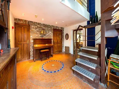 a living room with a piano and a staircase at De Appelgaard Voeren Estate in Berg