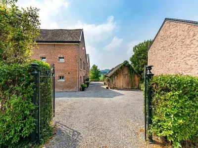 an entrance to a barn with a metal gate at De Appelgaard Voeren Estate in Berg