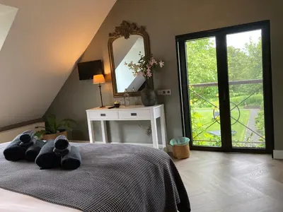 a teddy bear laying on a bed in a bedroom at Rue Haute by M&M 4 sterren bed en breakfast vlakbij Maastricht in Eben-Emael